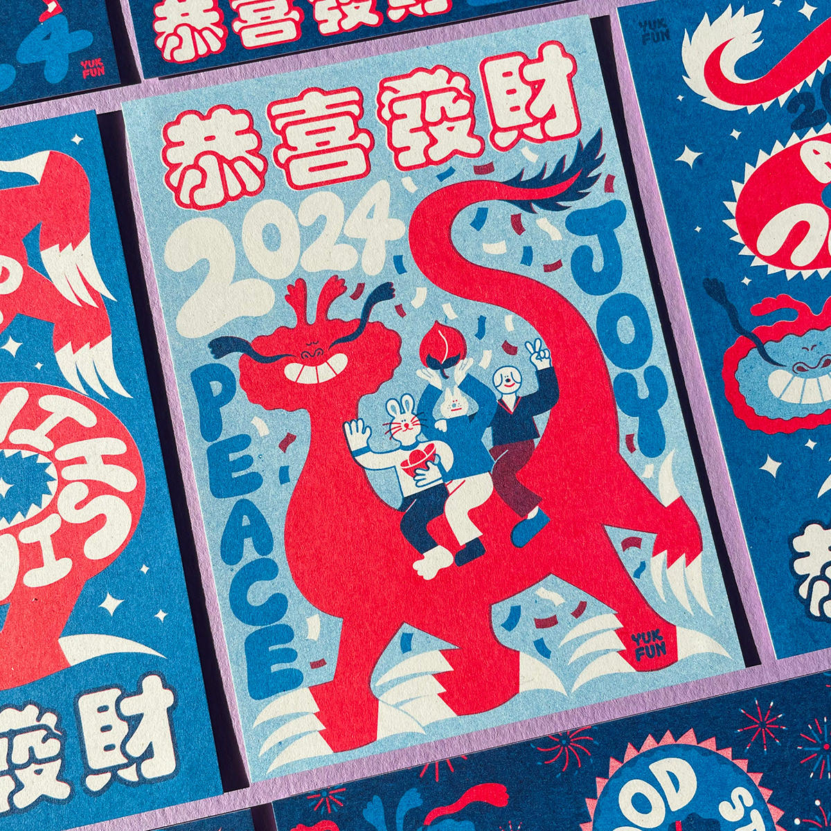 Photo of a riso printed Lunar New Year postcard. It features an illustration of a happy dragon. 