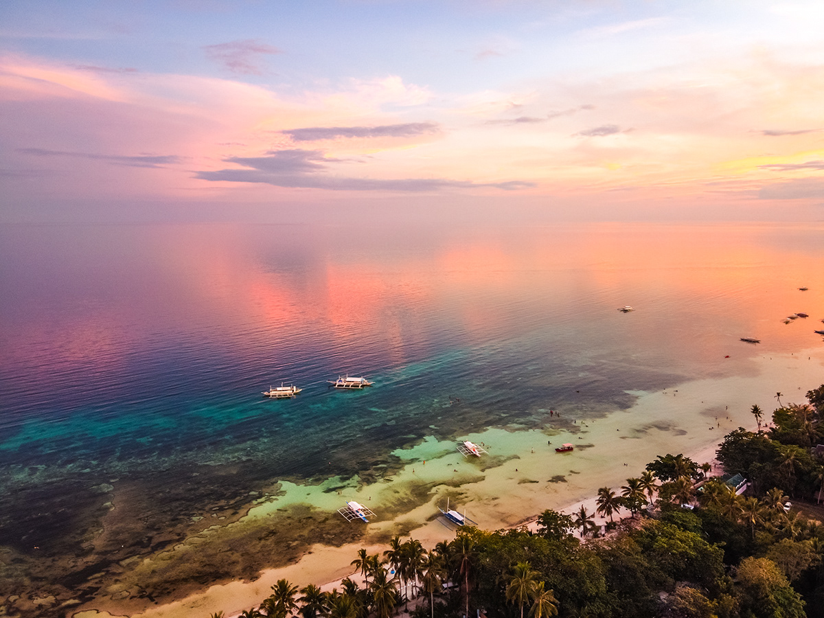 Aerial view of a sunset over an exotic beach in the Philippines.
