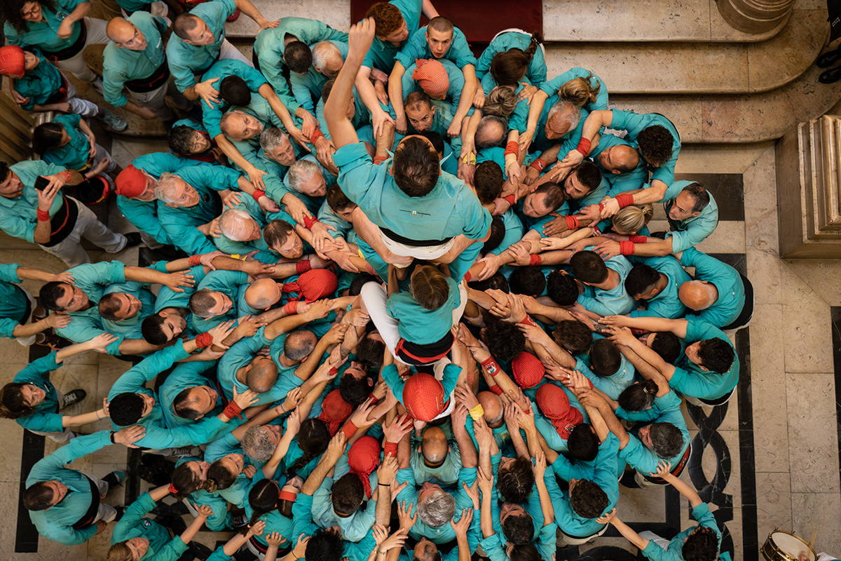 A big group of people come together to form the human towers, typical of Catalunya region in Spain.