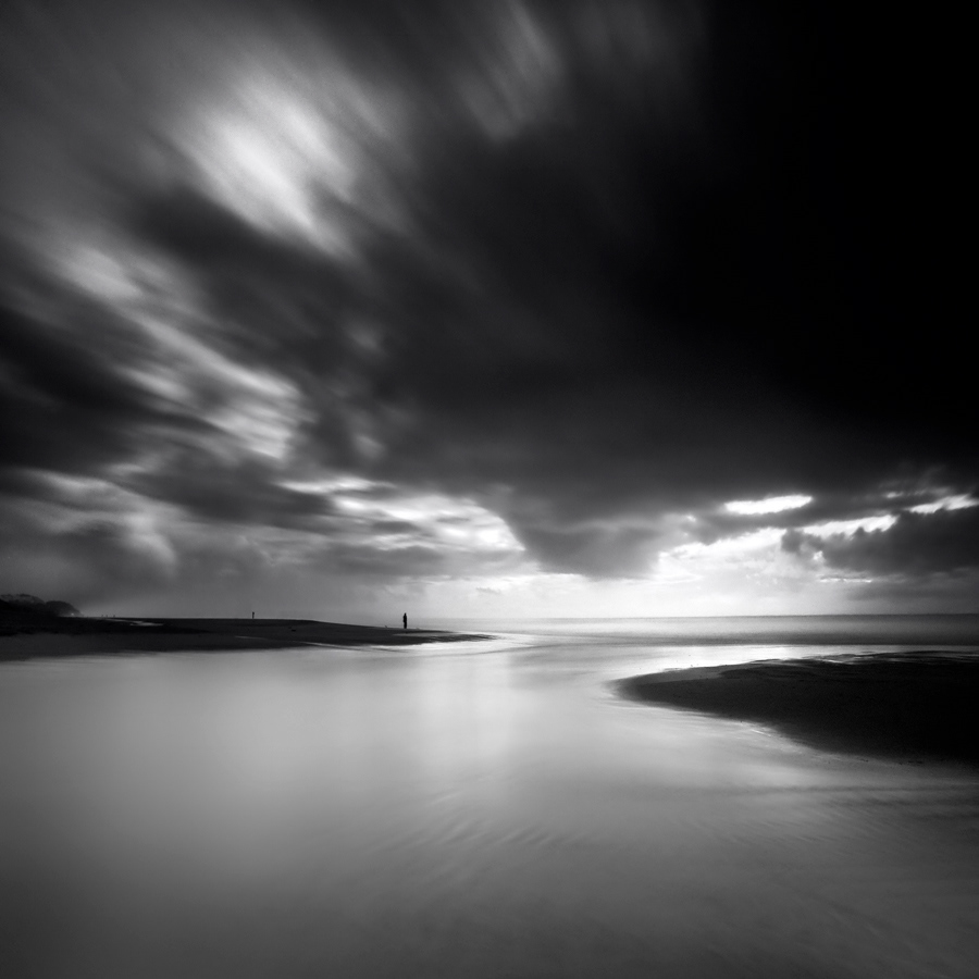 long exposure Ocean sea black and white water rocks sand Streaming clouds light