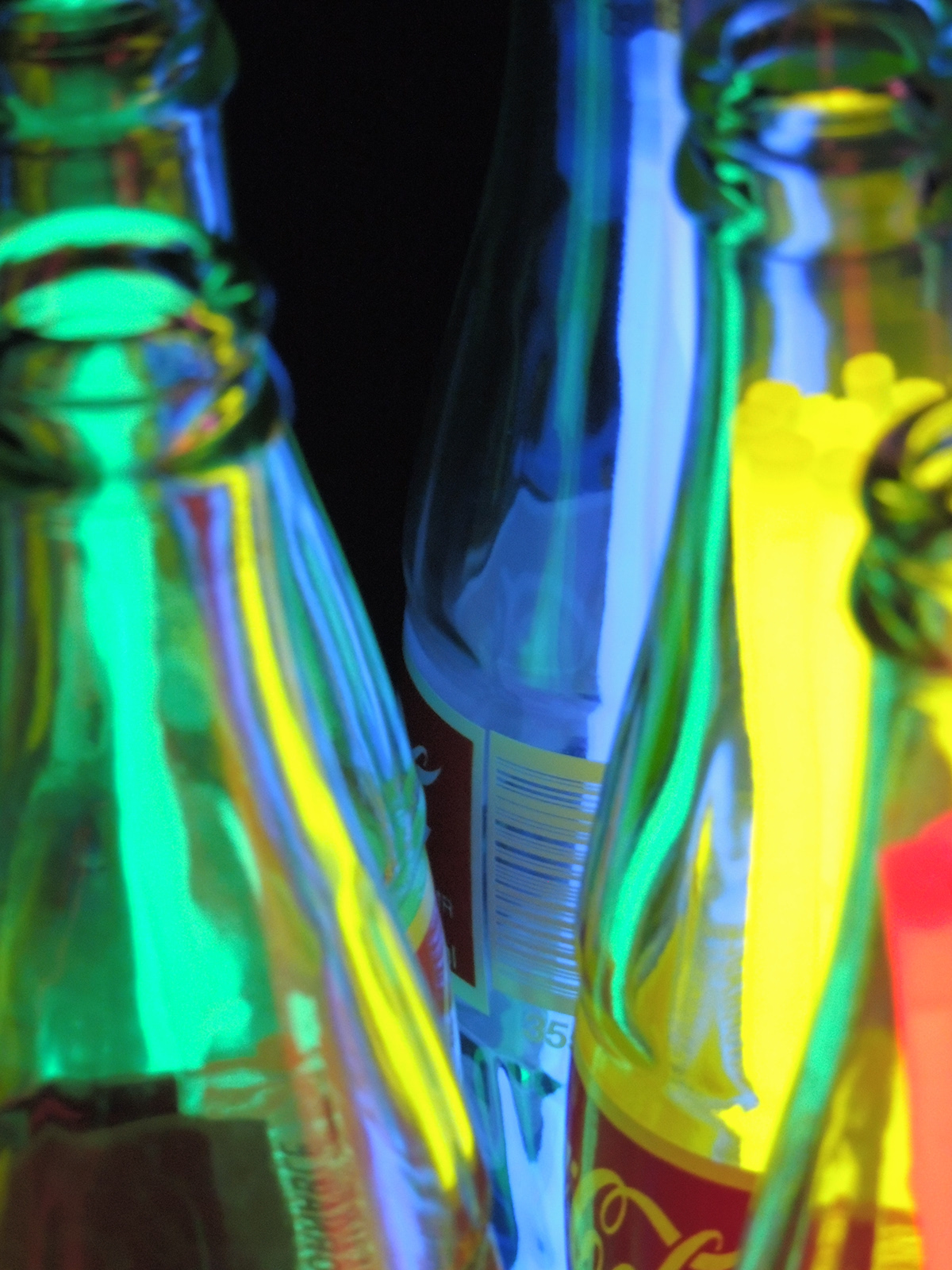 glowsticks bottles cola yellow green blue purple red neon lights abstract art depthoffield dark