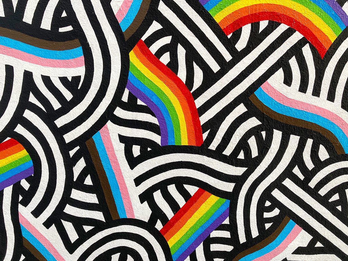 Closeup of a black and white mural with the progress pride flag colors by Stillo Noir