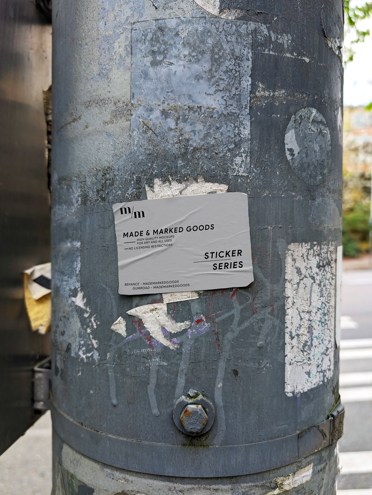 Free, fully-editable PSD rough sticker on a street post next to a bus and subway station mockup.