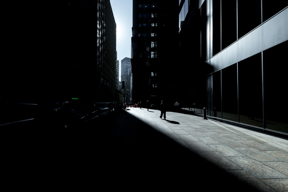 New York people buildings light dark Sun Wall street dowtown
