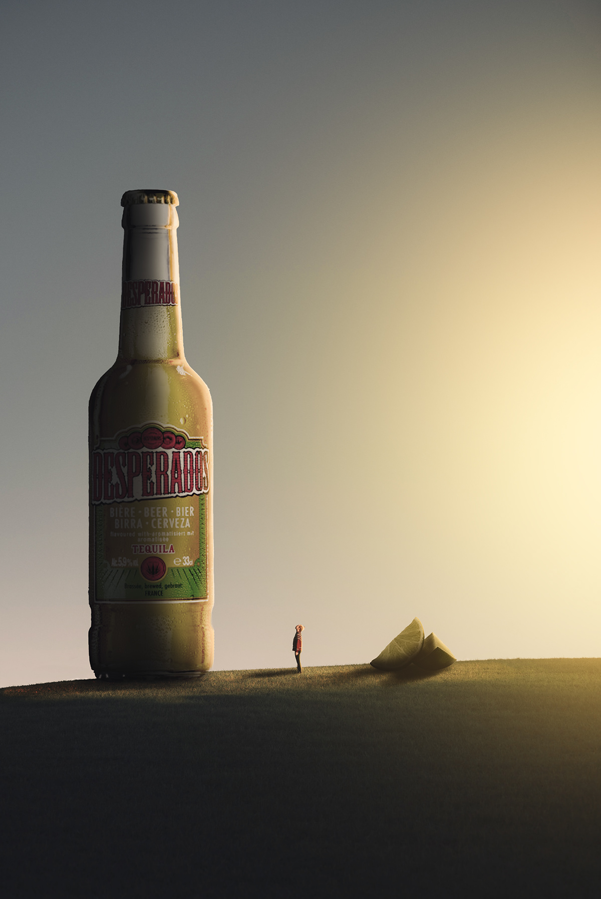 Tiny human standing on the field, looking up at huge bottle of Desperados beer and big lime wedges 