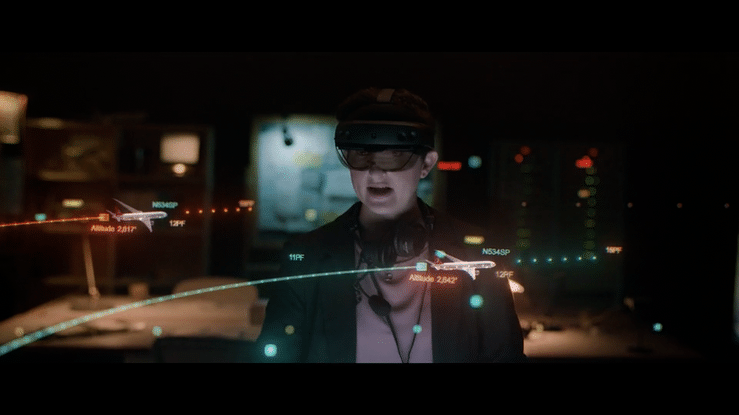 GIF: Homem utilizando o dispositivo HoloLens 2 e interagindo com o avatar de um colega de trabalho e um holograma.