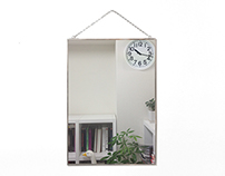 A wall-mounted clock that looks like a mirror