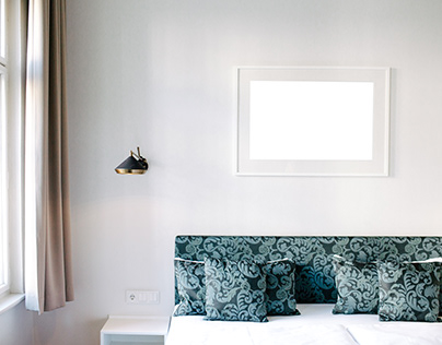 Photo frame on a white wall with sofa Free Mockup