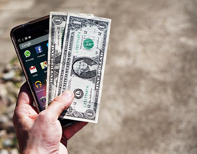 A smartphone and two dollar bills