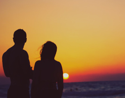 Young Couple On The Beach At Sunset