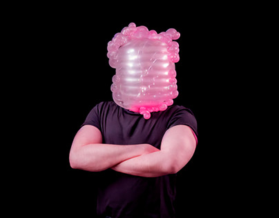 portrait of a man with pink balloons on his head