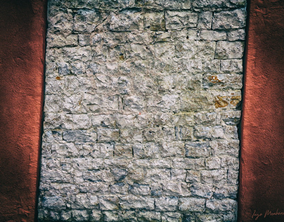 Crooked & abstract old brick wall between red concrete