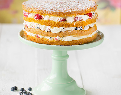 Big cake with cream, blueberries, raspberries