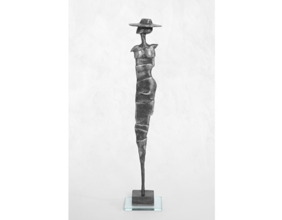 Pewter sculpture of "Girl witha hat" on glass base.