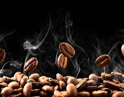 Grains of coffee are flying on a black background.