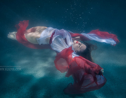 Girl in dress under water.