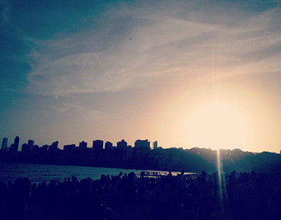 A beautiful sunset by the crowed beach.