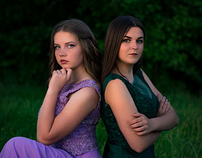 Portraits of two girls in dresses in nature