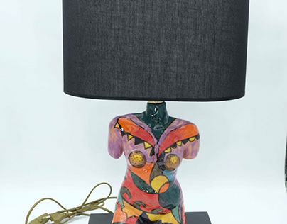 Ceramic female body lampshade with wooden base.
