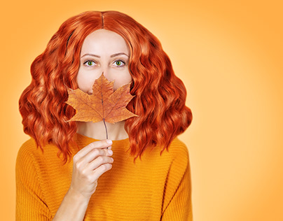 Red-haired girl with curly hair on a orange background