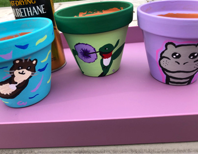 Hand painted flower pots otter, hummingbird,hippo