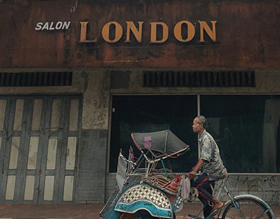 An Old Man Pedaling his Pedicab through the Shops